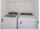 Laundry room with white washer and dryer and wire shelving for storage and convenience at 9080 Wildlight Trl, Wildwood, FL 34785