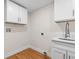 Bright laundry room with white cabinets and wood flooring at 1716 Palmer Ave, Winter Park, FL 32789