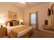 Cozy bedroom with a queen-size bed, wicker furnishings, and a window with blinds and curtains at 308 New Providence # 308, Davenport, FL 33897