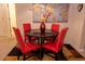 Stylish dining area with a dark wood table and four modern red chairs, complemented by a world map wall decor at 308 New Providence # 308, Davenport, FL 33897