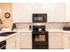 Modern kitchen features white cabinetry, black appliances, and subway tile backsplash, creating a clean and stylish space at 308 New Providence # 308, Davenport, FL 33897