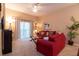 Cozy living room featuring a red sofa, sliding door access to a balcony, and tasteful decor at 308 New Providence # 308, Davenport, FL 33897