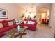 Cozy living room featuring red sofas, an open floorplan, and decor with views to the kitchen at 308 New Providence # 308, Davenport, FL 33897