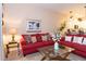 Inviting living room features red couches, an open floorplan, and decor with views to the kitchen at 308 New Providence # 308, Davenport, FL 33897