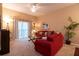 Cozy living room featuring a red sofa, sliding door access to a balcony, and tasteful decor at 308 New Providence # 308, Davenport, FL 33897