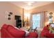 Comfortable living room featuring a plush red sofa, TV, and sliding glass doors to the outdoor balcony at 308 New Providence # 308, Davenport, FL 33897