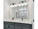 Bathroom featuring a double vanity with modern fixtures and a large mirror at 6086 Sacred Oak Ave, Mount Dora, FL 32757