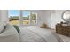 Comfortable bedroom with natural light, wood-look floors, and scenic views of the lush backyard at 6086 Sacred Oak Ave, Mount Dora, FL 32757