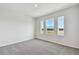 Bright bedroom with gray carpeting and serene window views at 6086 Sacred Oak Ave, Mount Dora, FL 32757