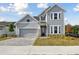 Two-story house with gray siding, stone accents, and a paved driveway at 6086 Sacred Oak Ave, Mount Dora, FL 32757