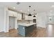 New kitchen showcases a spacious island with bar seating, stainless appliances, and ample cabinet space at 6086 Sacred Oak Ave, Mount Dora, FL 32757