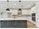 Modern kitchen with white cabinets, a large island, and stainless steel appliances at 6086 Sacred Oak Ave, Mount Dora, FL 32757