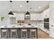 Bright kitchen features a large island with bar seating, stainless appliances, and modern pendant lighting at 6086 Sacred Oak Ave, Mount Dora, FL 32757
