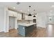 Modern kitchen with white cabinets, a large island, and stainless steel appliances at 6086 Sacred Oak Ave, Mount Dora, FL 32757