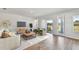 Spacious living room with hardwood floors, comfortable seating, and sliding glass doors to the backyard at 6086 Sacred Oak Ave, Mount Dora, FL 32757