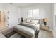Clean and minimalist bedroom featuring neutral paint, modern decor, and two side tables with lamps at 6075 Sacred Oak Ave, Mount Dora, FL 32757
