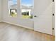 Bright bedroom with wood-look floors and view of backyard at 6075 Sacred Oak Ave, Mount Dora, FL 32757