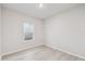 Simple bedroom with wood-look floors and a window at 6075 Sacred Oak Ave, Mount Dora, FL 32757
