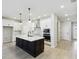 Modern kitchen featuring an island with a sink, pendant lighting, stainless steel appliances, and white cabinets at 6075 Sacred Oak Ave, Mount Dora, FL 32757