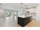 Modern kitchen with white cabinets, a large island, and light wood flooring at 6075 Sacred Oak Ave, Mount Dora, FL 32757