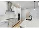 Modern kitchen featuring white subway tile backsplash and stainless steel range hood at 6075 Sacred Oak Ave, Mount Dora, FL 32757