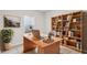 Bright office space with a large desk, built-in bookshelves, and natural light from a window at 6075 Sacred Oak Ave, Mount Dora, FL 32757