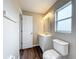 View of a bathroom with a white vanity, window, and toilet with a white door at 7713 Manor Dr, Lakeland, FL 33810