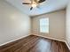 Bright bedroom featuring ceiling fan, wood floor and large window at 7713 Manor Dr, Lakeland, FL 33810