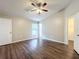 Bedroom features ceiling fan, closet, and dark wood-look flooring at 7713 Manor Dr, Lakeland, FL 33810