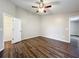 This bedroom has dark wood-style floors, a closet, and a ceiling fan at 7713 Manor Dr, Lakeland, FL 33810