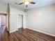 Bedroom features ceiling fan, closet, and dark wood-look flooring at 7713 Manor Dr, Lakeland, FL 33810