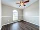 This bedroom features dark wood flooring, a ceiling fan, chair railing, and a window for plenty of natural light at 7713 Manor Dr, Lakeland, FL 33810