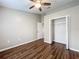 Bedroom features ceiling fan, closet, and dark wood-look flooring at 7713 Manor Dr, Lakeland, FL 33810