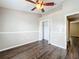 Bedroom features ceiling fan, closet, and dark wood-look flooring at 7713 Manor Dr, Lakeland, FL 33810