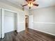 Bedroom features ceiling fan, closet, and dark wood-look flooring at 7713 Manor Dr, Lakeland, FL 33810