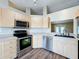 Updated kitchen featuring stainless steel appliances, light wood cabinets, and lots of natural light at 7713 Manor Dr, Lakeland, FL 33810