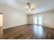 Spacious living room featuring sleek wood-look floors, neutral walls, and a ceiling fan at 7713 Manor Dr, Lakeland, FL 33810