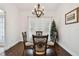 Dining room with wood floors, glass table, decorative chairs, and hanging light fixture at 5407 County Road 125, Wildwood, FL 34785