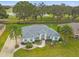 Stunning single-story home featuring a well-manicured lawn, palm trees, and golf course views at 5407 County Road 125, Wildwood, FL 34785