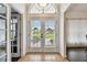 Bright foyer featuring double glass doors, tile flooring, and elegant transom window at 5407 County Road 125, Wildwood, FL 34785