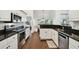 Modern kitchen with stainless steel appliances, white cabinets, and black countertops at 5407 County Road 125, Wildwood, FL 34785