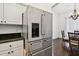 Kitchen with stainless steel refrigerator and adjacent dining area with chandelier at 5407 County Road 125, Wildwood, FL 34785