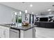 Modern kitchen island with granite countertop, stainless steel dishwasher, and pool view at 116 Prestwick Grande Dr, Daytona Beach, FL 32124