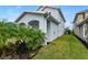 Side yard of house with manicured lawn and tropical plants at 116 Prestwick Grande Dr, Daytona Beach, FL 32124