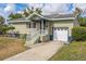 Charming ranch home with light green siding, a covered entryway, and a spacious driveway at 836 Kensington St, Lakeland, FL 33803