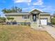 Ranch style home with a light green exterior, landscaped lawn, and a two-car garage at 836 Kensington St, Lakeland, FL 33803