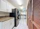 Modern kitchen with black refrigerator and white cabinets at 3017 Jon Jon Ct, Orlando, FL 32822