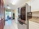 Kitchen with stainless steel refrigerator and access to patio at 3017 Jon Jon Ct, Orlando, FL 32822