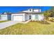 Inviting two-story home featuring a lush green lawn, attached garage, and a welcoming entrance pathway at 13490 Leaping Water Way, Astatula, FL 34705