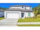 Charming two-story home with a well-maintained lawn, attached garage and modern architectural details at 13490 Leaping Water Way, Astatula, FL 34705